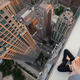 Illustration for article titled People tip toeing on top of buildings over cities will always be scary